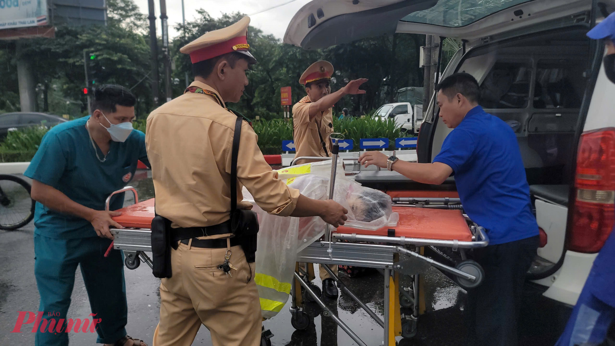 CSGT cùng nhân viên y tế di chuyển bệnh nhi ra xe.