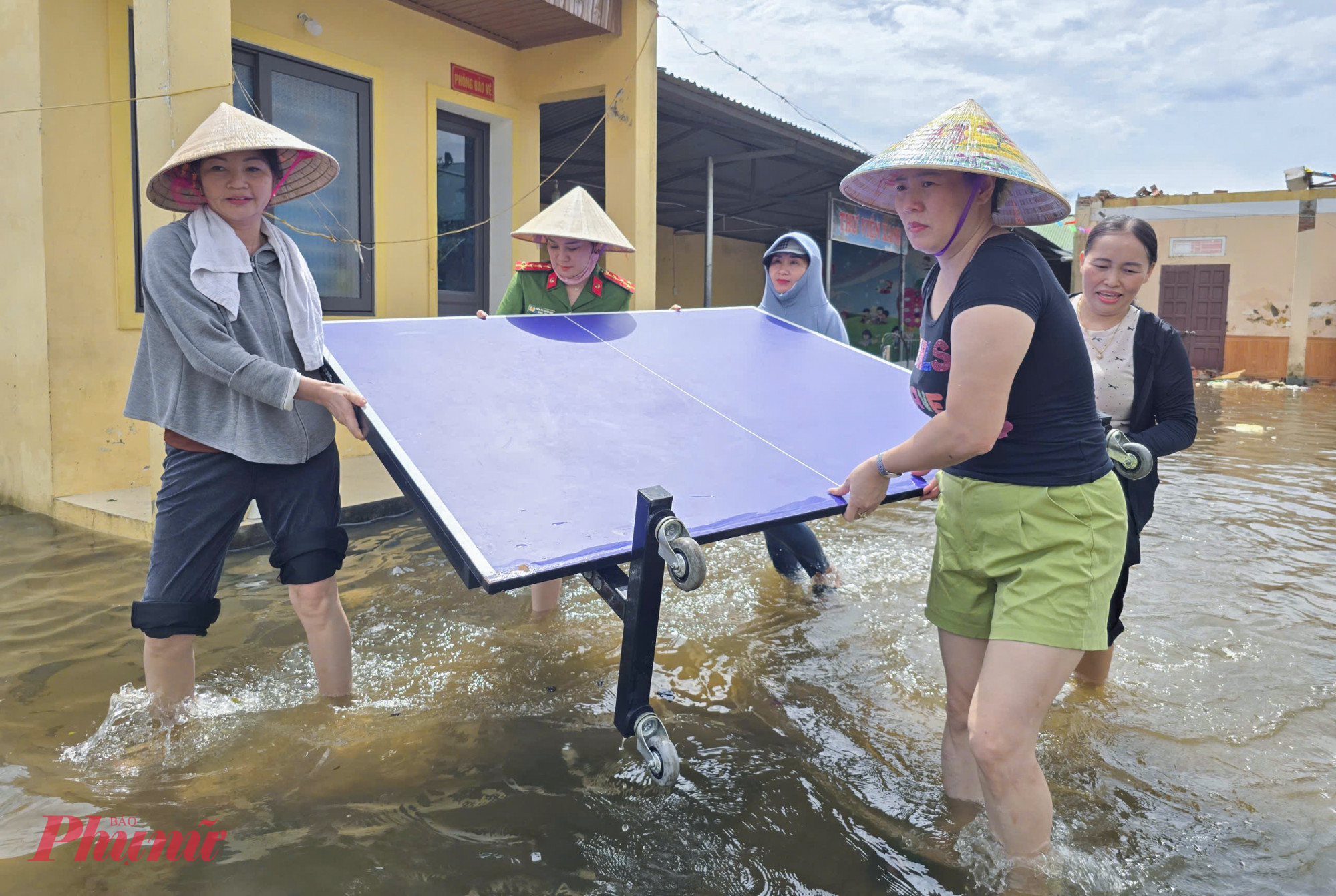 Bão tan, nước lũ lại dâng cao tràn vào trường học. Giữa ngổn ngang bùn đất, tập thể giáo viên đã chủ động trở lại trường, xắn tay dọn dẹp khuôn viên, khiêng bàn ghế, lau chùi sàn lớp học và gom dọn thiết bị hư hỏng.