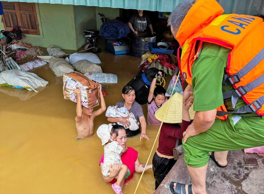 Công an xã Tân Kỳ, tỉnh Nghệ An hỗ trợ người dân vùng bị ngập sâu sơ tán đến các trường học tránh lũ  - ẢNH: MINH LOAN
