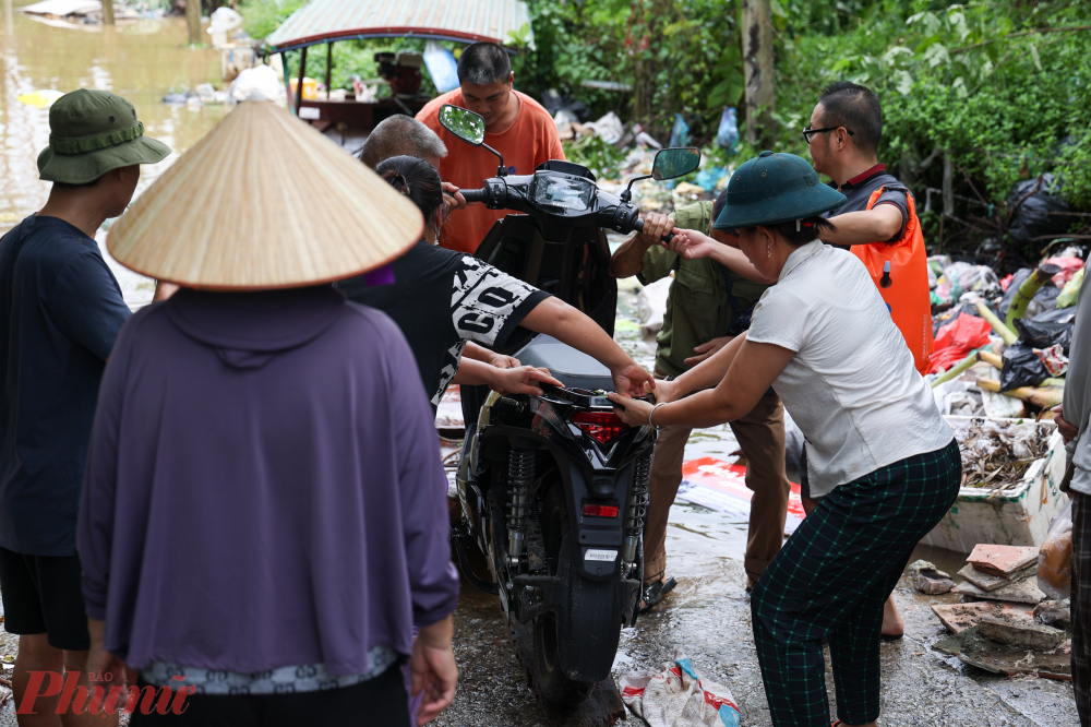 Một số người cố gắng lội nước sâu để về nhà, song do dòng chảy mạnh, nguy hiểm nên đành quay lại chờ thuyền đến hỗ trợ.
