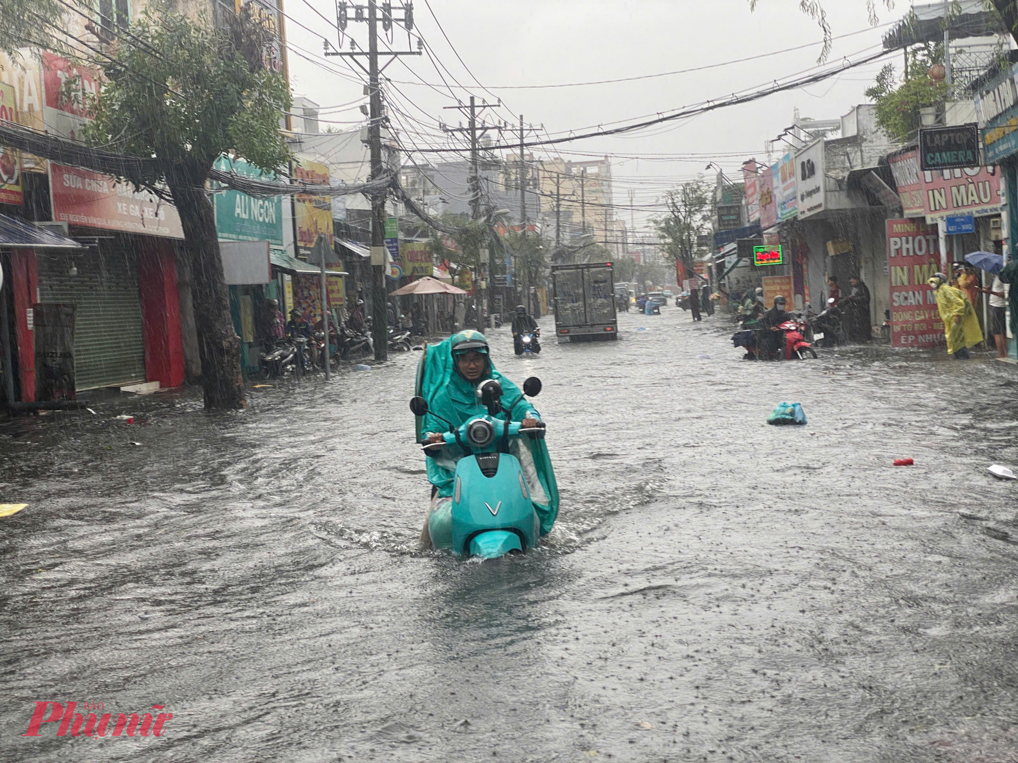 Tài xế xe ôm công nghệ chật vật chở khách trên đường ngập.