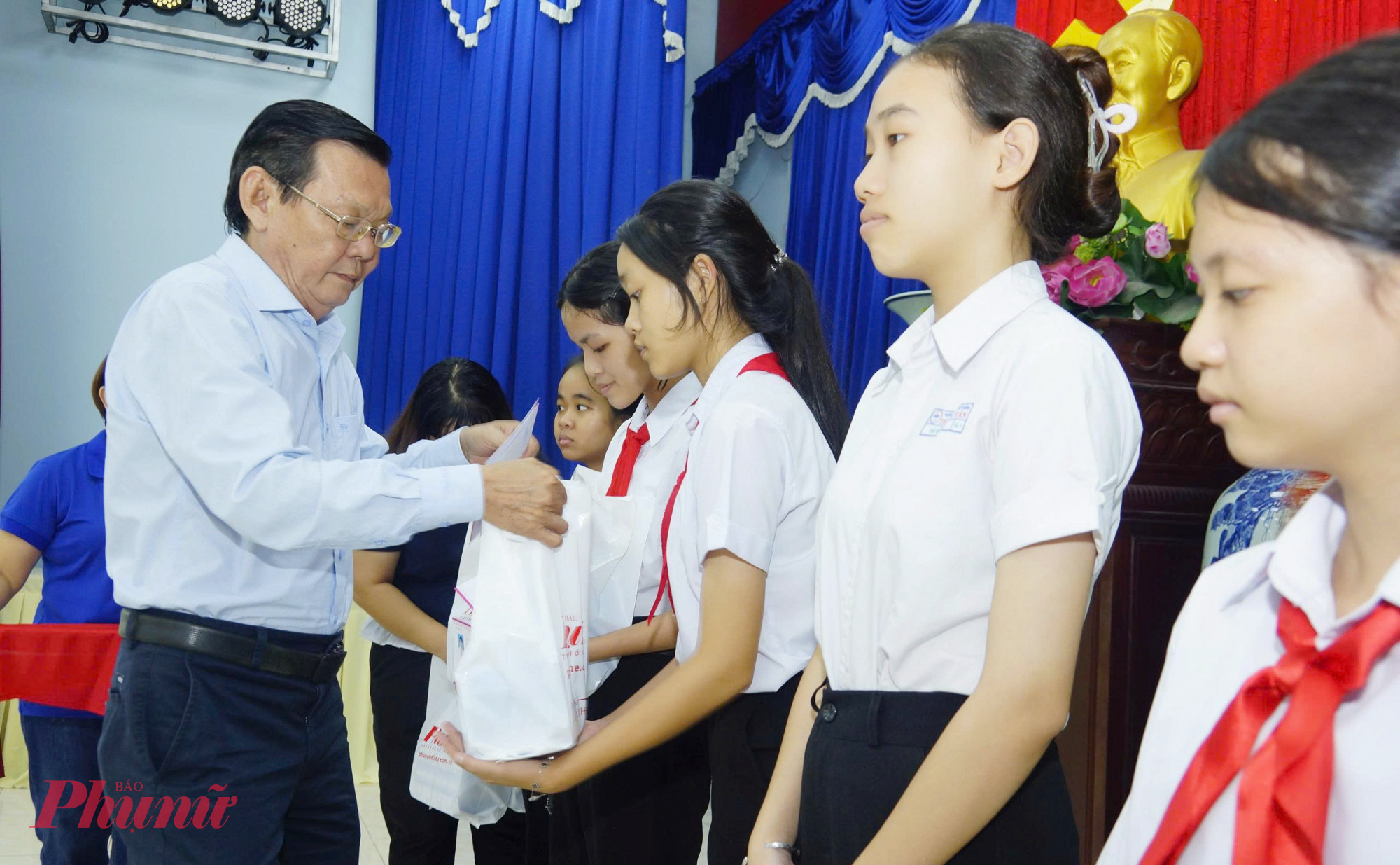 Ông Nguyễn Tấn Phong - Chủ tịch Hội Nhà báo TPHCM - trao học bổng cho các nữ sinh - Ảnh: Phùng Huy 