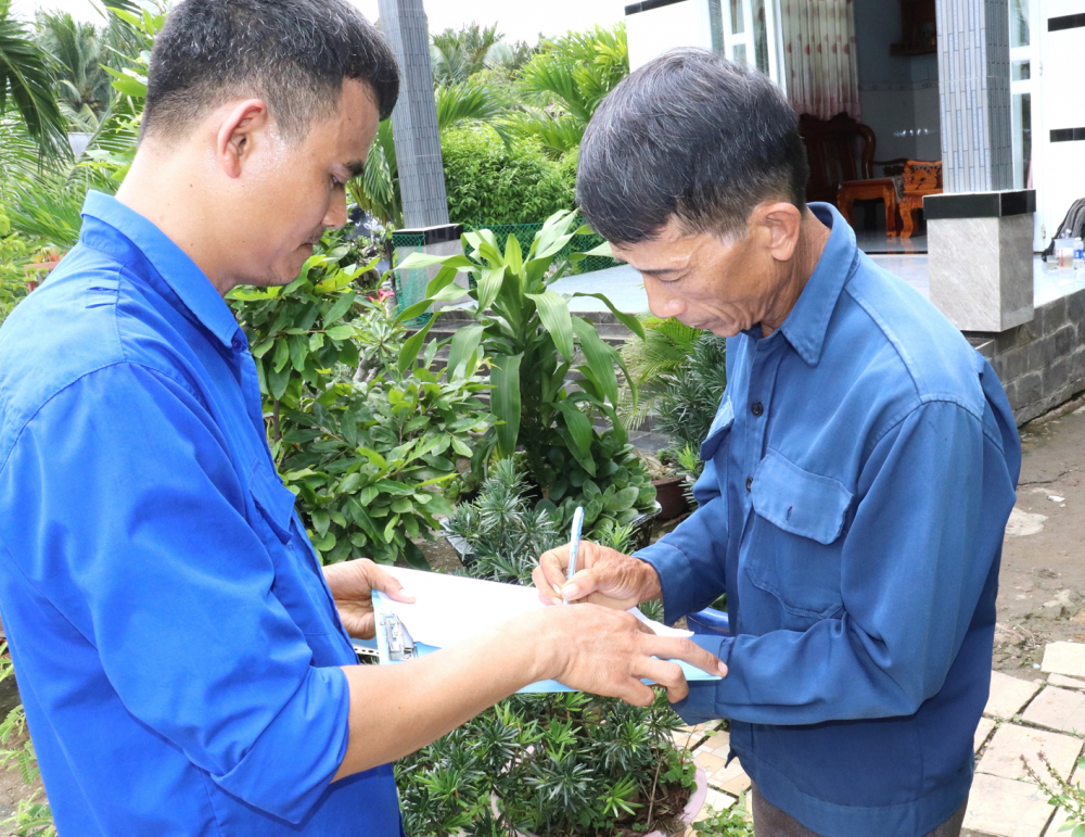 Ông Nguyễn Văn Thành (bên phải) ở doi Mỹ Khánh ký hợp đồng nhận đồng hồ nước riêng cho gia đình