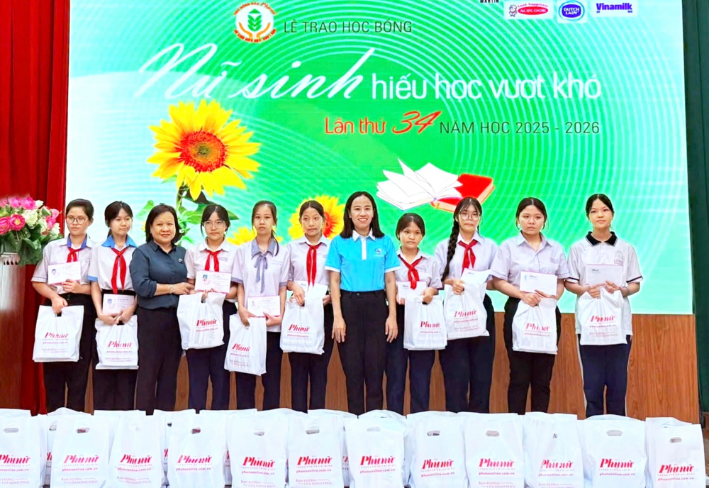Bà Võ Ngọc Thanh Trúc (thứ năm từ phải qua) - Chủ tịch Hội LHPN TPHCM và bà Tạ Thị Nam Hồng (thứ ba từ trái qua) - Phó tổng biên tập Báo Phụ nữ TPHCM - trao học bổng cho các nữ sinh tại phường Bà Rịa - ẢNH: DIỄM TRANG