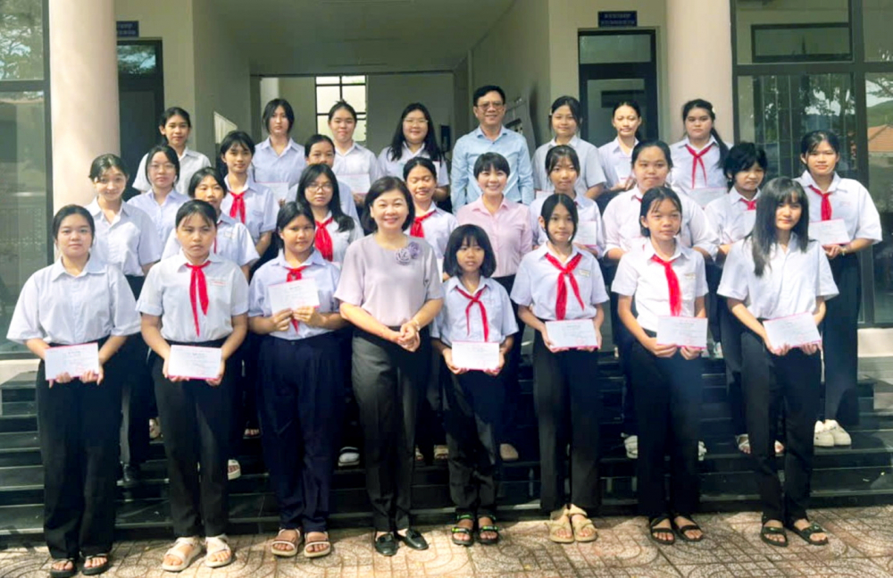Bà Lý Việt Trung (hàng đầu, thứ tư từ trái qua) - Tổng biên tập Báo Phụ nữ TPHCM, ông Nguyễn Ngọc Hồi (hàng thứ ba, thứ năm từ trái qua) - Phó giám đốc Sở Văn hóa - Thể thao TPHCM và bà Nguyễn Thị Thu Thảo (hàng thứ hai, thứ năm từ phải qua)  - Chủ tịch Hội LHPN đặc khu Côn Đảo trao học bổng cho các em nữ sinh tại đặc khu Côn Đảo - ẢNH: T.N.