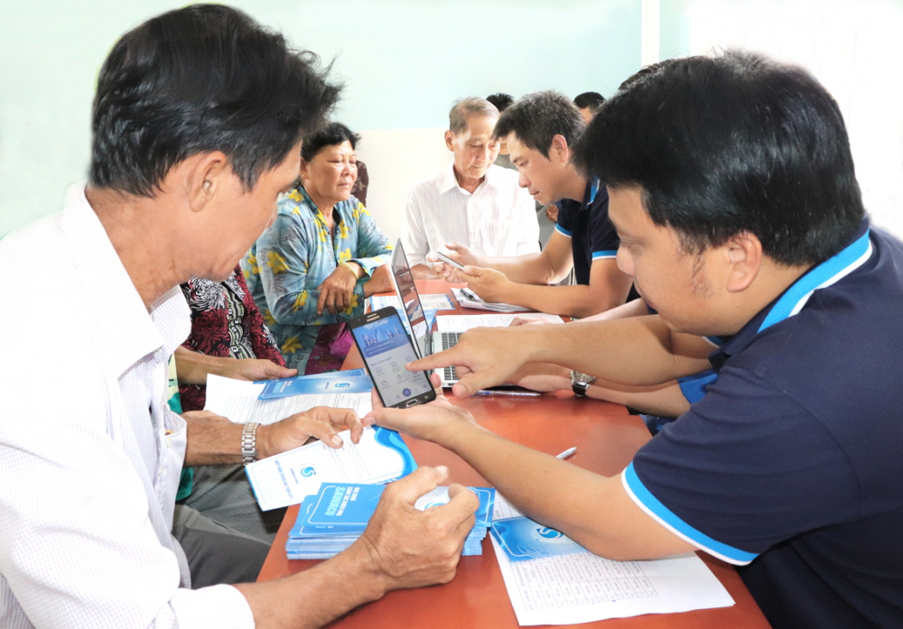 Nhân viên Xí nghiệp Cấp nước Cần Giờ hướng dẫn người dân cài app SAWACO CSKH và cách sử dụng