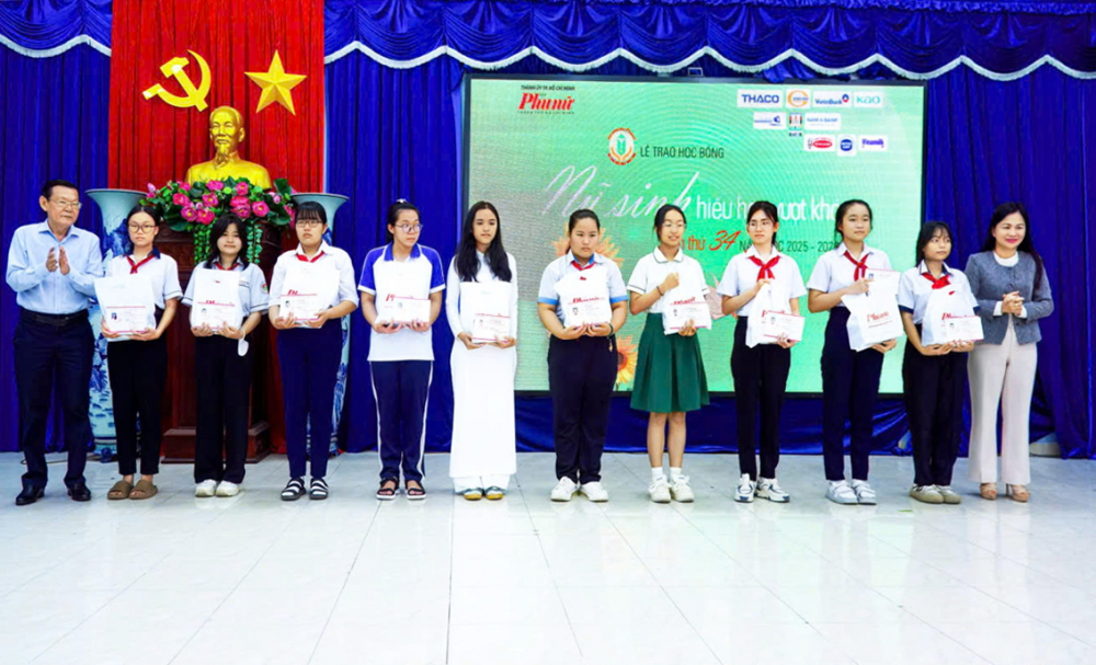 Ông Nguyễn Tấn Phong (bìa trái) - Chủ tịch Hội Nhà báo TPHCM - và bà Phạm Thị Vân Anh (bìa phải) - Phó tổng biên tập Báo Phụ nữ TPHCM  - trao học bổng cho con em hội viên phụ nữ có hoàn cảnh khó khăn tại 36 phường, xã ở TPHCM (thuộc tỉnh Bình Dương trước đây) - ẢNH: PHÙNG HUY