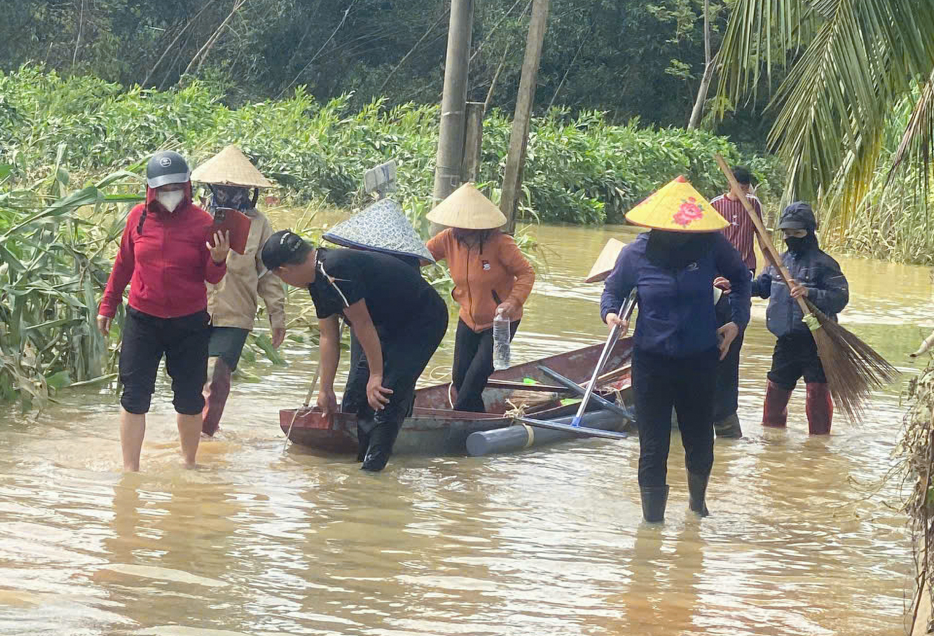 Tổ dọn nhà của phụ nữ xóm Đông Du mang theo dụng cụ đi hỗ trợ người dân dọn dẹp - Ảnh: Khánh Trung