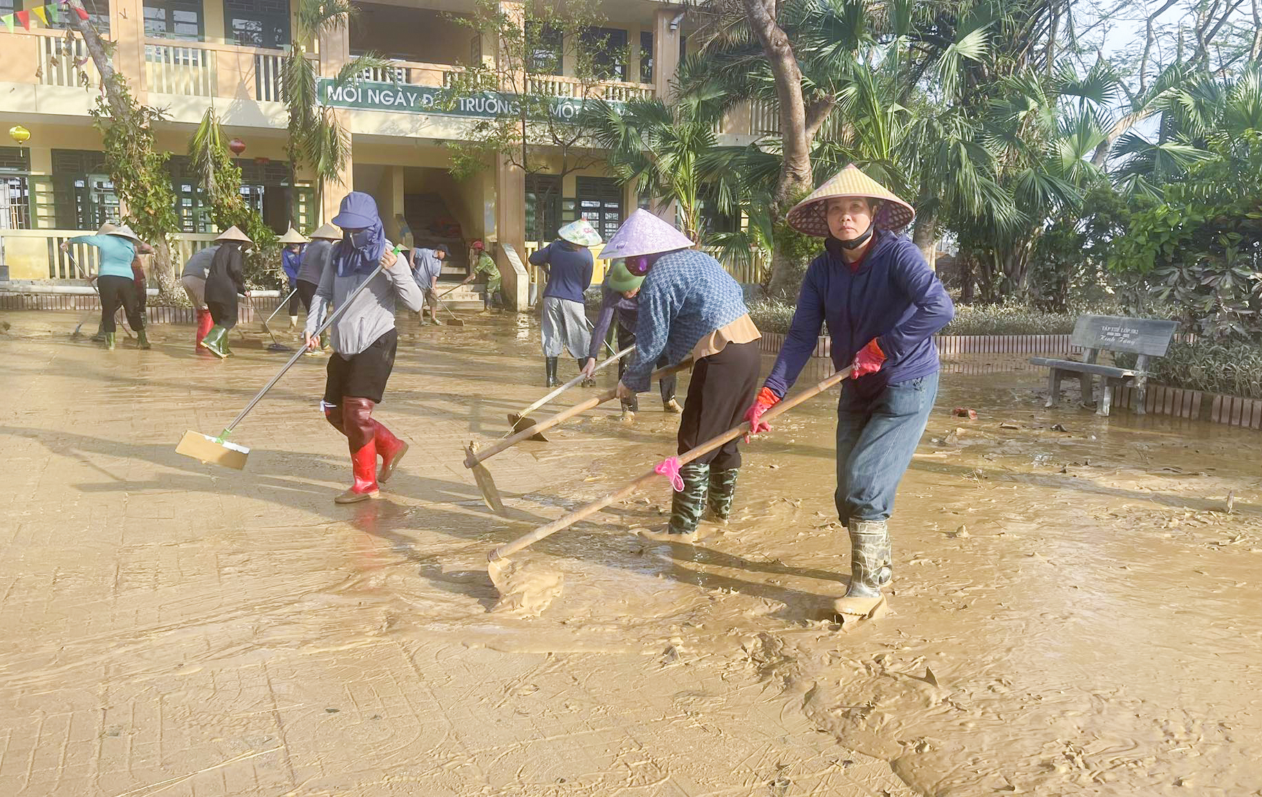 Giáo viên, phụ huynh Trường tiểu học Phạm Hồng Thái (xã Lam Thành) cào bùn non khi lũ rút - Ảnh: Khánh Trung