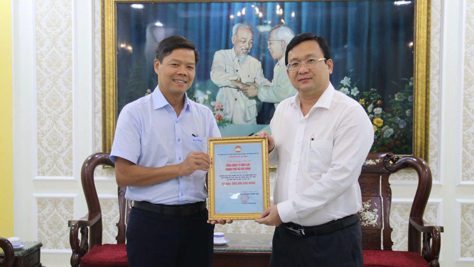 Ông Phan Hồng Ân - Phó chủ tịch Ủy ban Mặt trận Tổ quốc Việt Nam (bên phải) trao thư cảm ơn đến tổng công ty Điện lực TPHCM - Ảnh: EVNHCMC