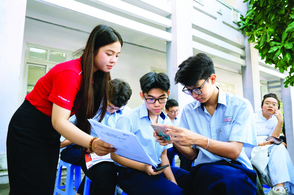 Nhân viên Trường đại học Công nghệ TPHCM (HUTECH) đang tư vấn tuyển sinh cho học sinh Trường THPT Hoàng Hoa Thám ẢNH: NGUYỄN LOAN