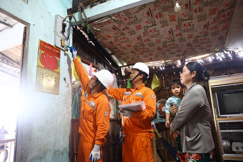 Công nhân Công ty Điện lực Cà Mau hướng dẫn người dân sử dụng điện an toàn - Ảnh Huy Hùng - TTXVN