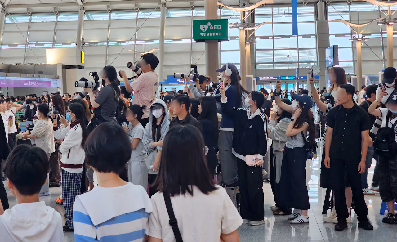 hâm mộ tập trung trước sảnh khởi hành của Sân bay quốc tế Incheon để chụp ảnh các nhóm nhạc thần tượng khởi hành ra nước ngoài. ảnh: chosun
