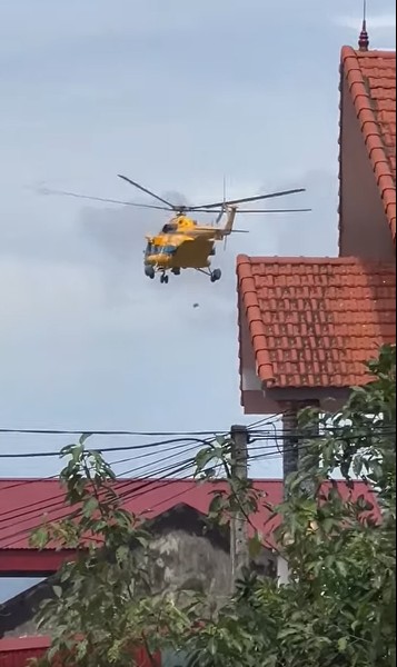 Trực thăng của Bộ Quốc phòng thả hàng hóa cứu trợ đến khu vực người dân bị cô lập bởi nước lũ. Ảnh: cắt từ clip người dân cung cấp