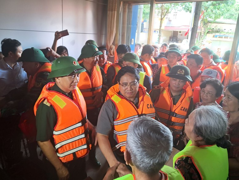 Thủ tướng Phạm Minh Chính tới hỏi thăm người dân bị lụt - ảnh: VGP