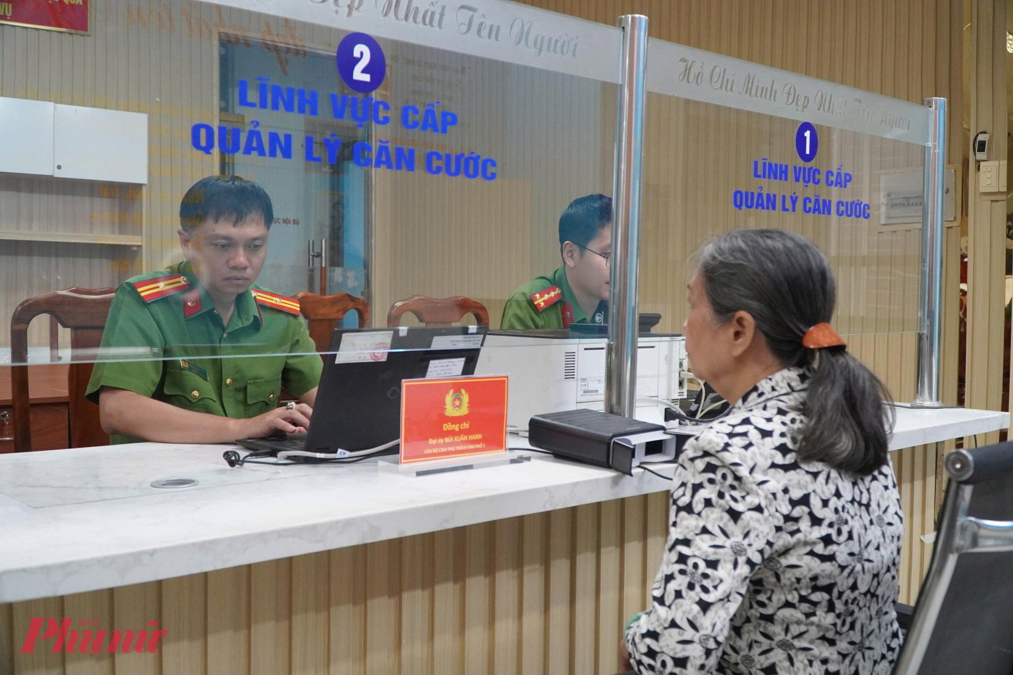Công an phường sẵn sàng phục vụ, lắng nghe và giải đáp mọi thắc mắc của người dân trong quá trình làm thủ tục - Ảnh: Thanh Tâm