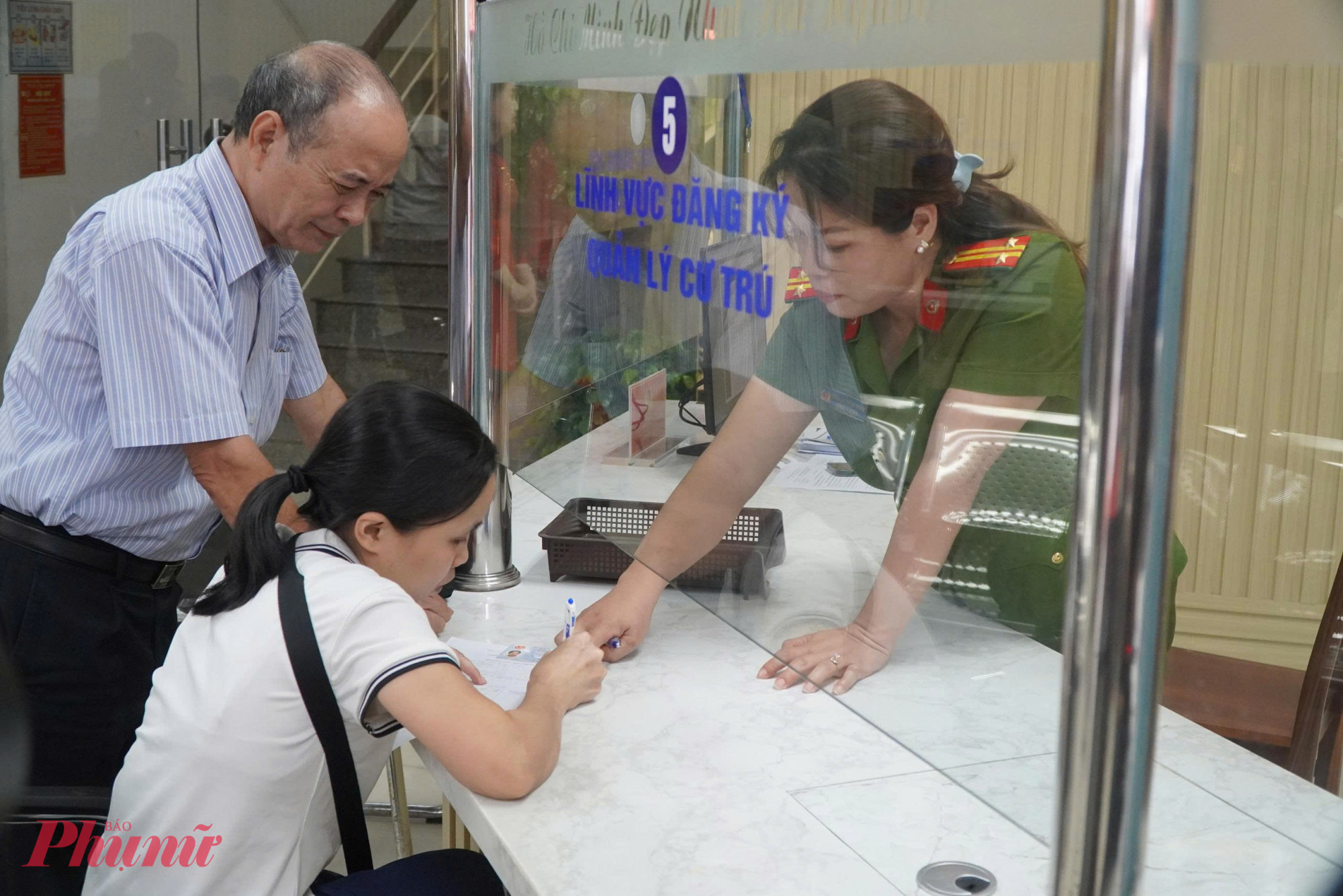 Cán bộ công an tận tình hướng dẫn người dân điền thông tin, giúp quy trình thủ tục diễn ra nhanh gọn, chính xác - Ảnh: Thanh Tâm