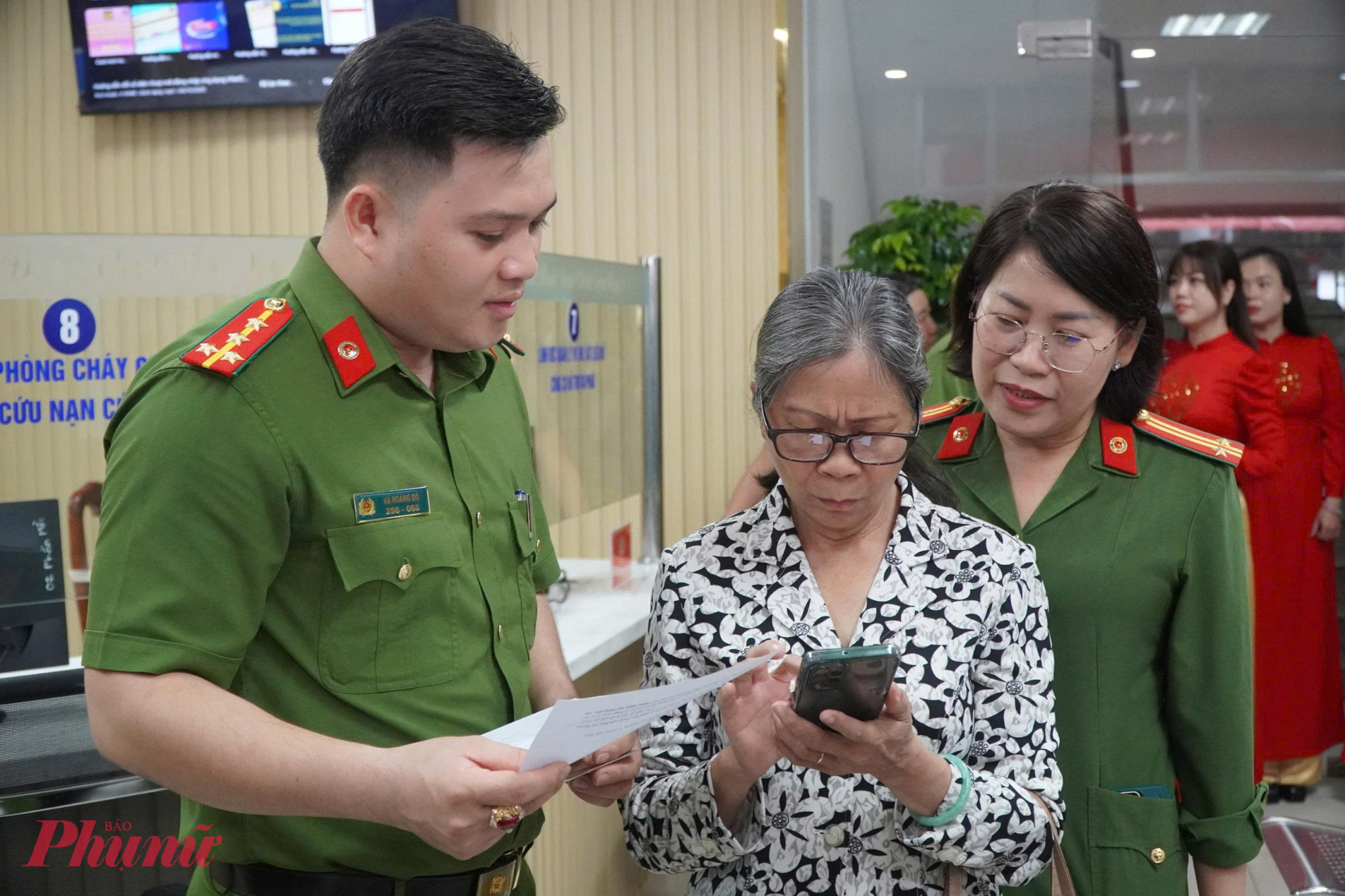 Cán bộ trẻ hướng dẫn người cao tuổi làm thủ tục cấp đổi giấy tờ trên hệ thống điện tử - Ảnh: Thanh Tâm