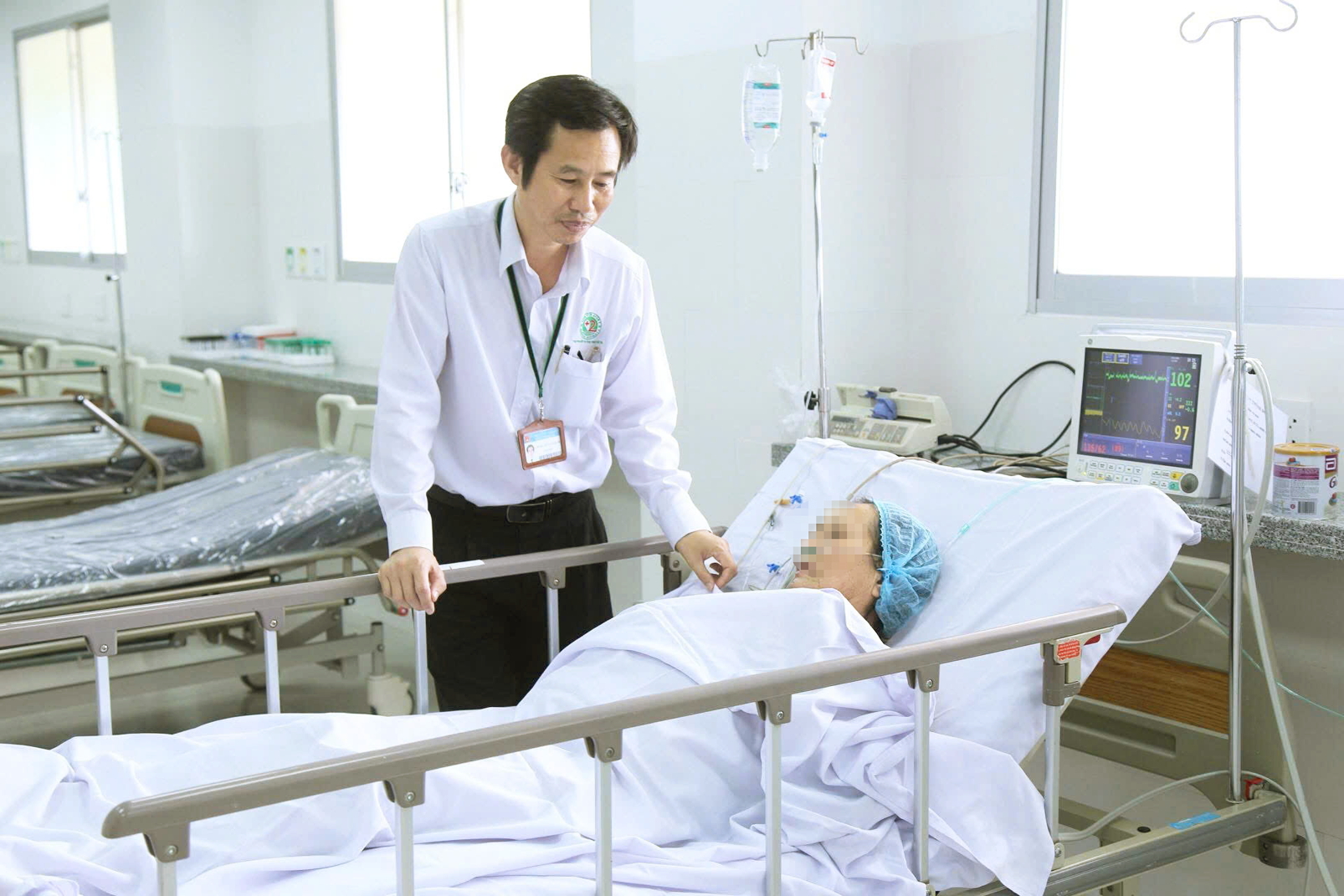 Bác sĩ Trần Văn Khanh thăm hỏi bệnh nhân lớn tuổi đang điều trị tại bệnh viện