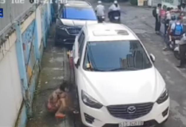 Đậu xe bên đường và câu chuyện bị "làm luật" Hình ảnh được cho là của người phụ nữ lớn tuổi đặt bàn chông vào bánh xe của xe ô tô đậu bên đường vì chắn chỗ để thùng rác của bà - Ảnh: Cắt từ clip