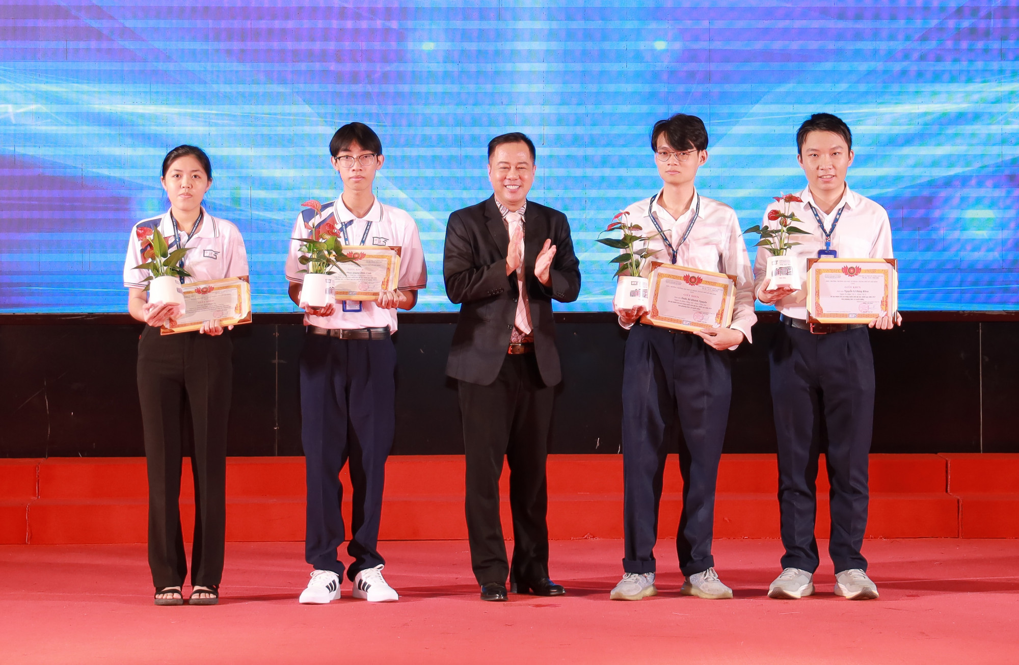 Doãn Bá Khánh Nguyên (thứ 2 từ trái qua) và các tan sinh viên có thành tích xuất sắc được nhà trường trao học bổng- Ảnh: HCMUE