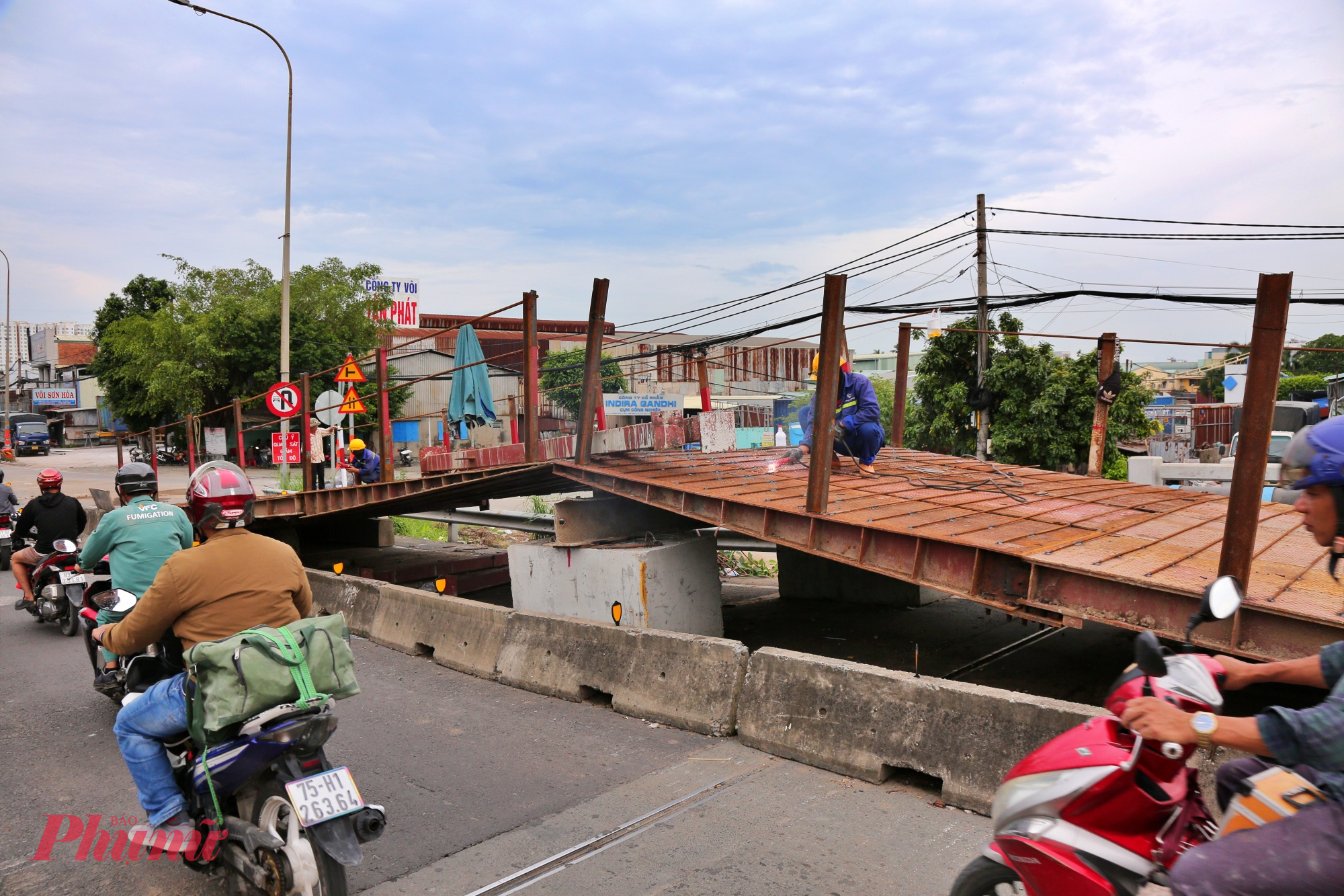 Song song đó, đơn vị thi công đang dựng hai cầu sắt tạm ở hai nhịp đầu và cuối cầu để tạo lối đi an toàn cho xe máy trong suốt thời gian thi công. 