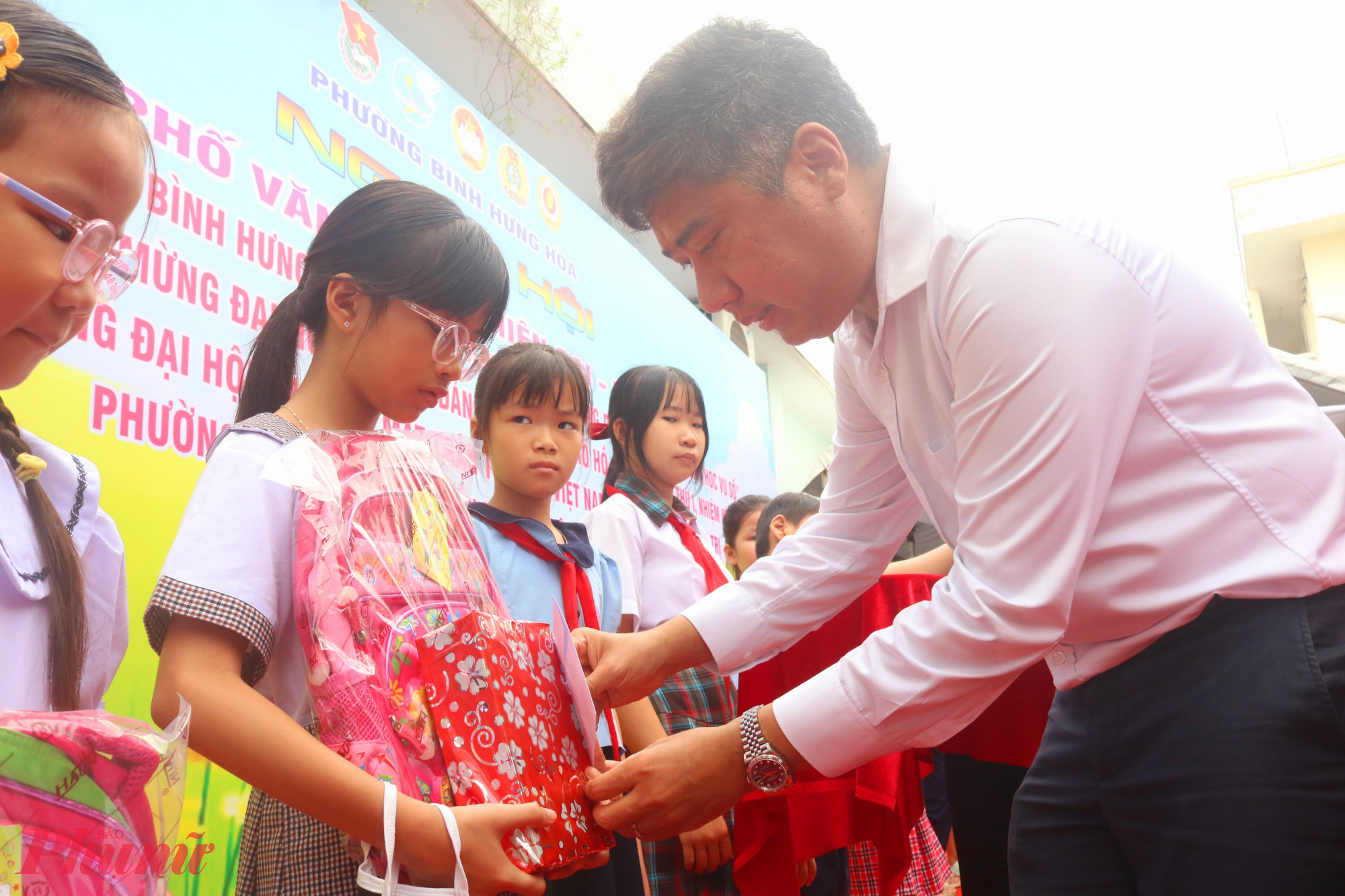 Ông Nguyễn Việt Quế Sơn – Bí thư Đảng ủy, Chủ tịch HĐND phường Bình Hưng Hoà – trao học bổng cho các em học sinh - Ảnh: Mẫn Nhi 