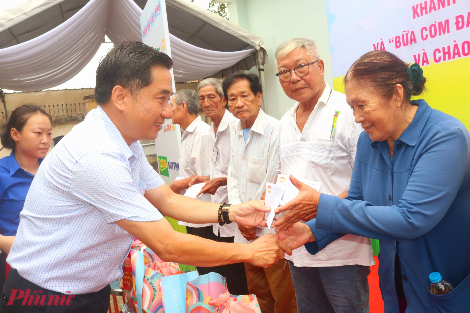 Ông Mai Tiến Dũng – Phó bí thư thường trực Đảng ủy phường Bình Hưng Hoà – trao quà đến các bác, các dì có hoàn cảnh khó khăn - Ảnh: Mẫn Nhi 