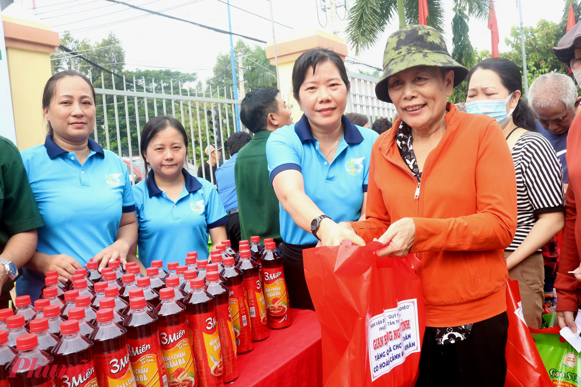 Bà Phạm Thị Mộng Hằng – Phó chủ tịch thường trực Ủy ban MTTQ, Chủ tịch Hội LHPN phường Tân Thới Hiệp (thứ 2, từ phải qua)– trao quà từ “Gian hàng nghĩa tình” cho người dân - Ảnh: Mẫn Nhi