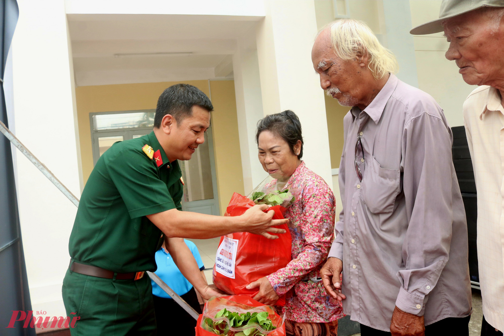 Trung tá Nguyễn Trần Tấn Nghĩa – Phó Chính ủy Trung đoàn Gia Định – tặng rau xanh cho người dân - Ảnh: Mẫn Nhi