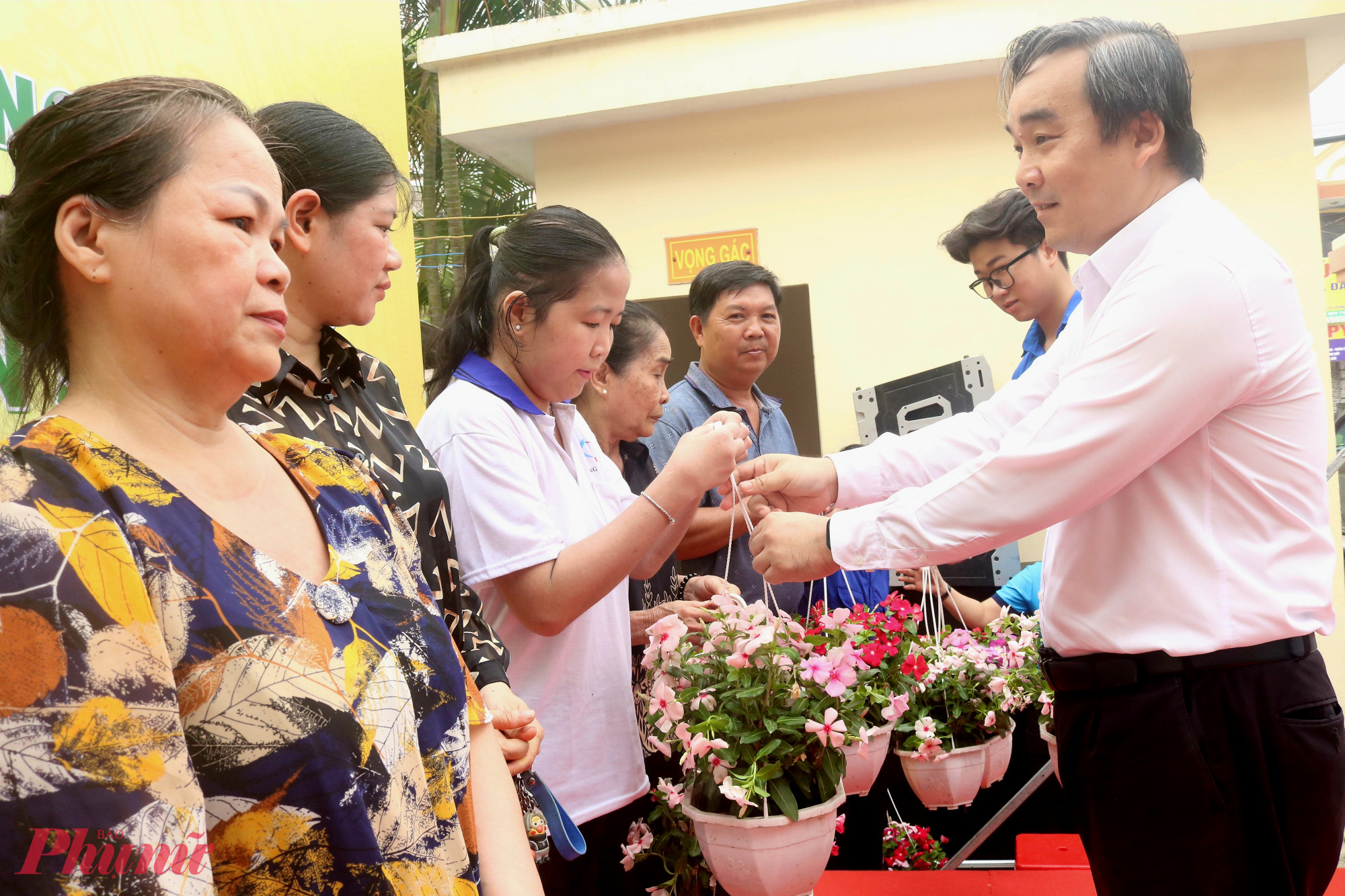 Ông Nguyễn Tấn Lực – Phó bí thư thường trực Đảng ủy phường Tân Thới Hiệp -  trao chậu hoa đến đại diện các hộ dân - Ảnh: Mẫn Nhi
