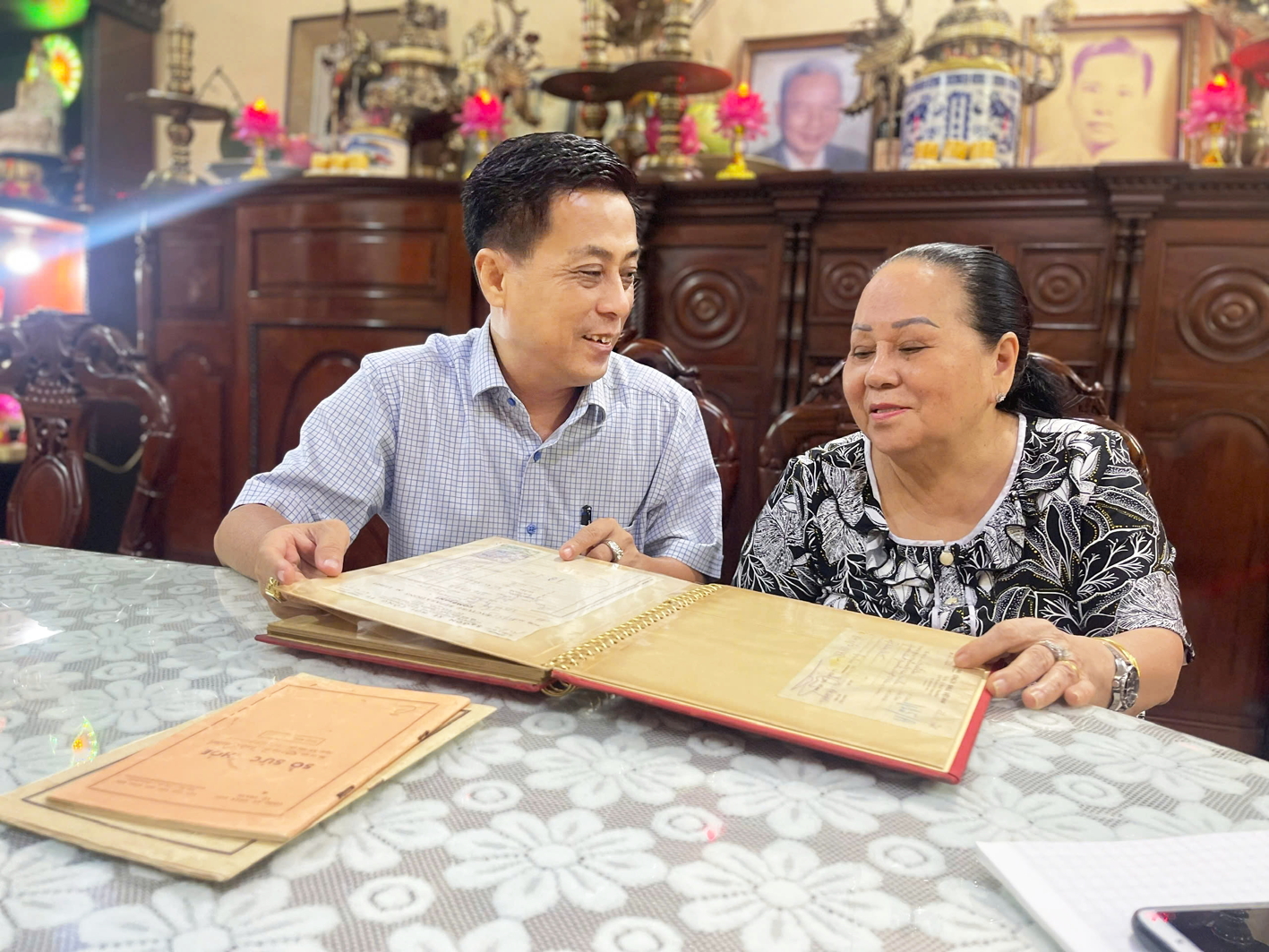 Ông Trần Vũ Bình (trái) cùng mẹ là bà Đặng Thị Thiệp - vợ của Anh hùng Lực lượng vũ trang nhân dân Trần Văn Lai - bên những kỷ vật của gia đình - ẢNH: TÔ DIỆU HIỀN