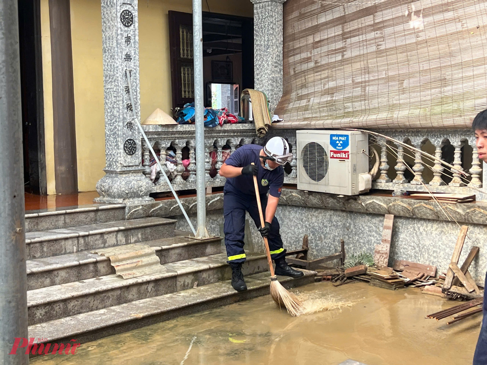 Cảnh sát lấm lem bùn đất, hỗ trợ người dân dọn nhà.