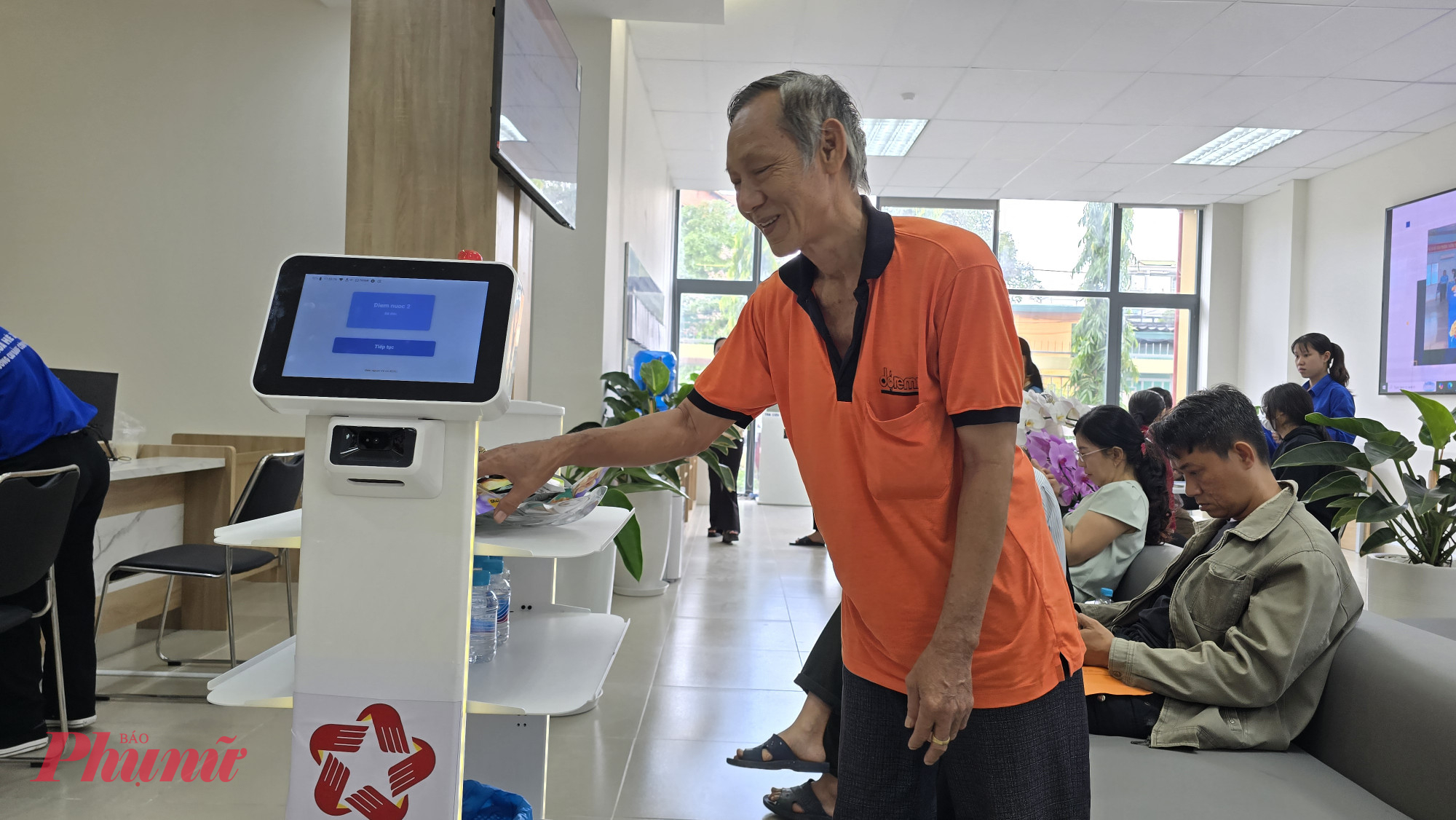 Người dân thích thú với robot mang bánh, kẹo, nước phục vụ miễn phí người dân đến làm thủ tục tại Trung tâm Trung tâm Phục vụ hành chính công phường Thủ Đức 