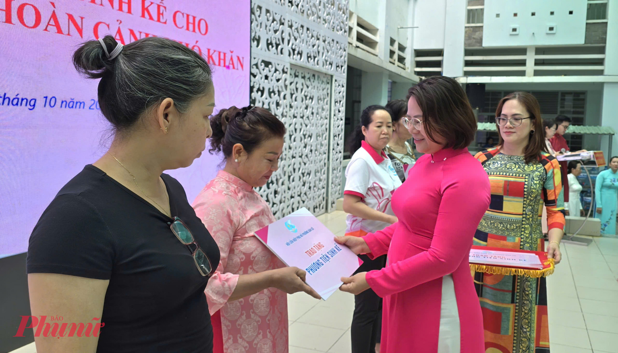 Bà Đoàn Thị Cẩm Tú - Chủ tịch Ủy ban MTTQVN phường Bàn Cờ - trao bảng tượng trưng tặng phương tiện sinh kế cho phụ nữ khó khăn - Ảnh: Trang Nguyễn