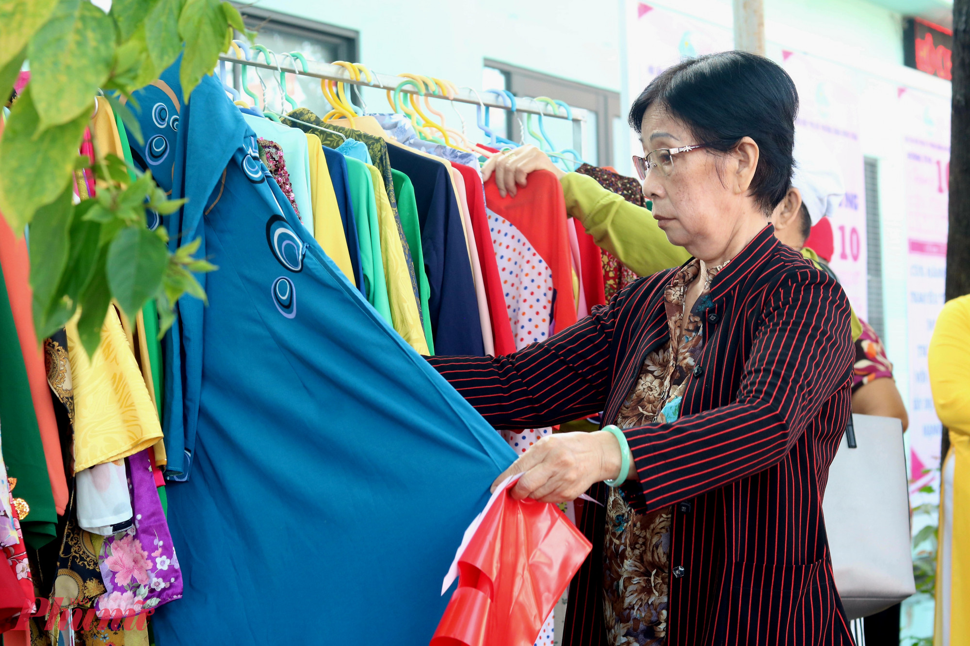 Các dì, các chị thoải mái lựa chọn bộ áo dài ưng ý tại khu vực gian hàng “Áo dài yêu thương” - Ảnh: Mẫn Nhi