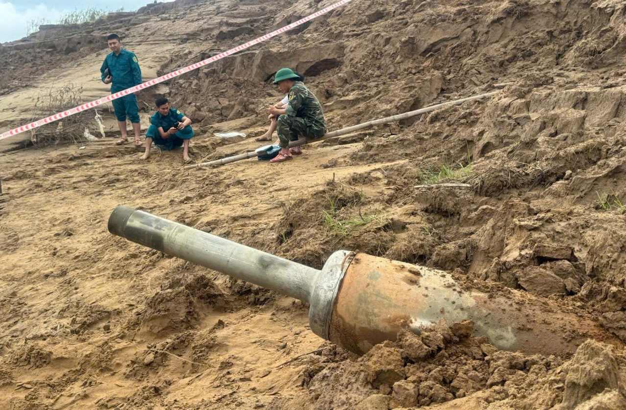 Lực lượng chức năng xã Đô Lương căng dây bảo vệ khu vực phát hiện bom - Ảnh: Văn Mỹ