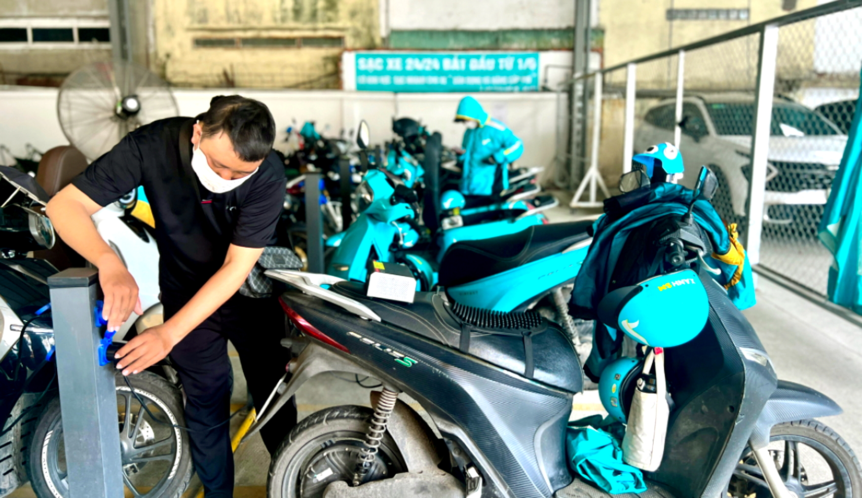 Khách hàng đang sạc pin xe điện tại chuỗi “Cà phê trạm sạc & sửa chữa 3T” ở đường Phan Văn Trị, phường Gò Vấp, TPHCM