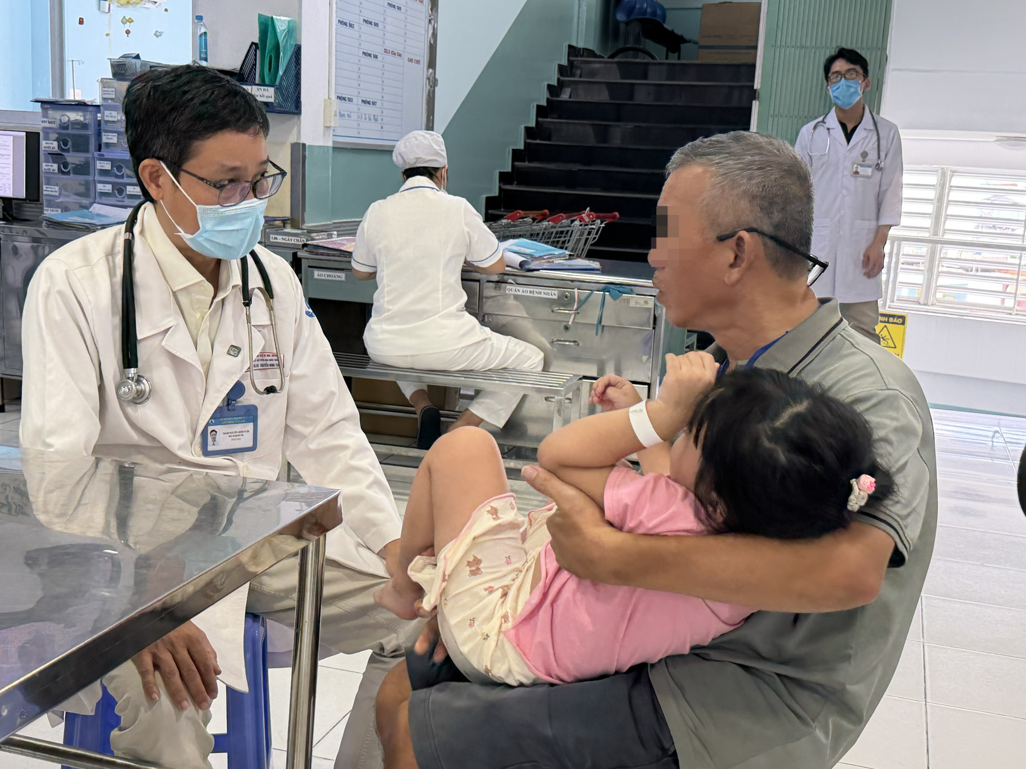 Thạc sĩ - bác sĩ Nguyễn Minh Tuấn đang khám cho một trường hợp bị sốt cao (ảnh: Thanh Huyền)
