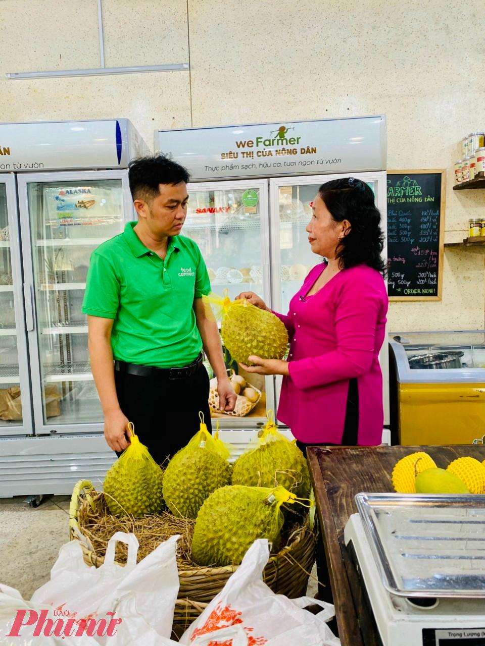 Chị Nguyễn Thị Thinh - Giám đốc HTX Nông nghiệp Tân Phú, tỉnh Vĩnh Long (bên phải) giới thiệu sản phẩm sầu riêng chất lượng cao của HTX với đối tác - Ảnh: CTV