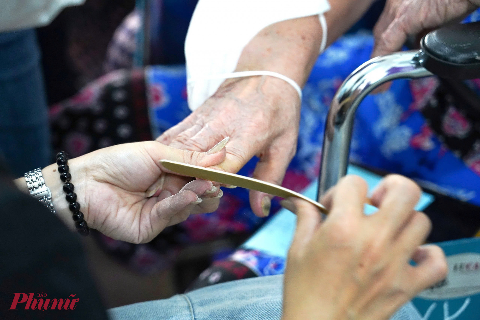 Tình nguyện viên chăm chút móng tay cho một nữ bệnh nhân làm điệu