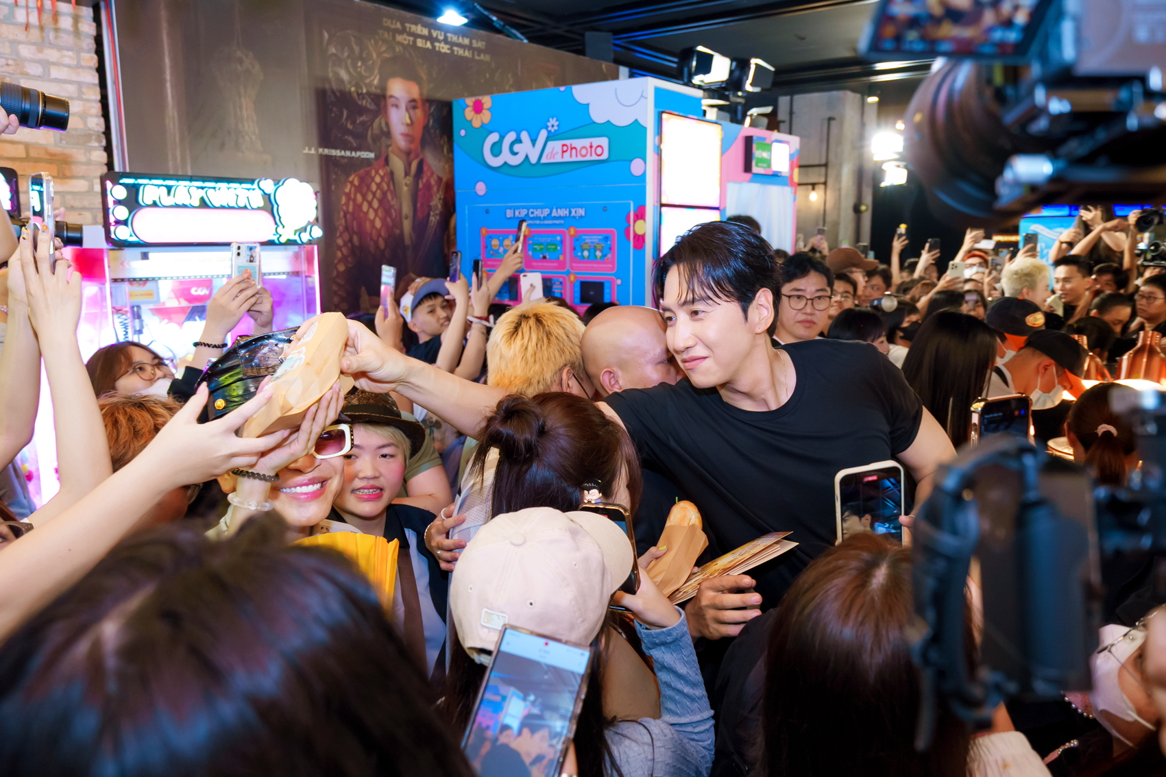 Tài tử Lee Kwang Soo thân thiện phát bánh mì cho người hâm mộ trong buổi ra mắt phim Tay anh giữ một vì sao - Nguồn ảnh: CJ