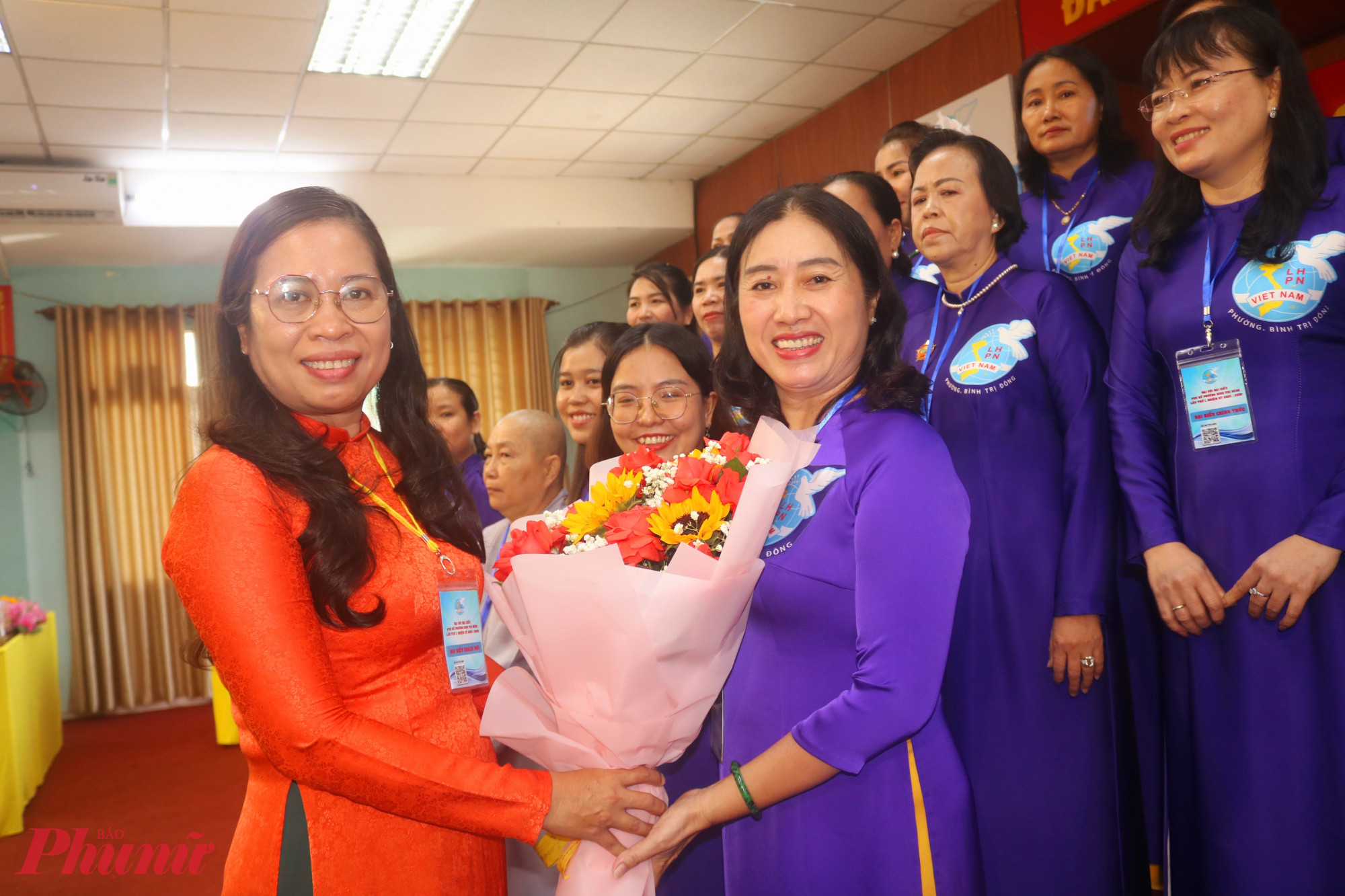 Bà Nguyễn Thị Bé Hai – Phó bí thư thường trực Đảng ủy phường Bình Trị Đông – trao hoa chúc mừng bà Lê Thị Sa Đam và Ban chấp hành Hội LHPN phường Bình Trị Đông nhiệm kỳ mới - Ảnh: Thảo Nguyên 