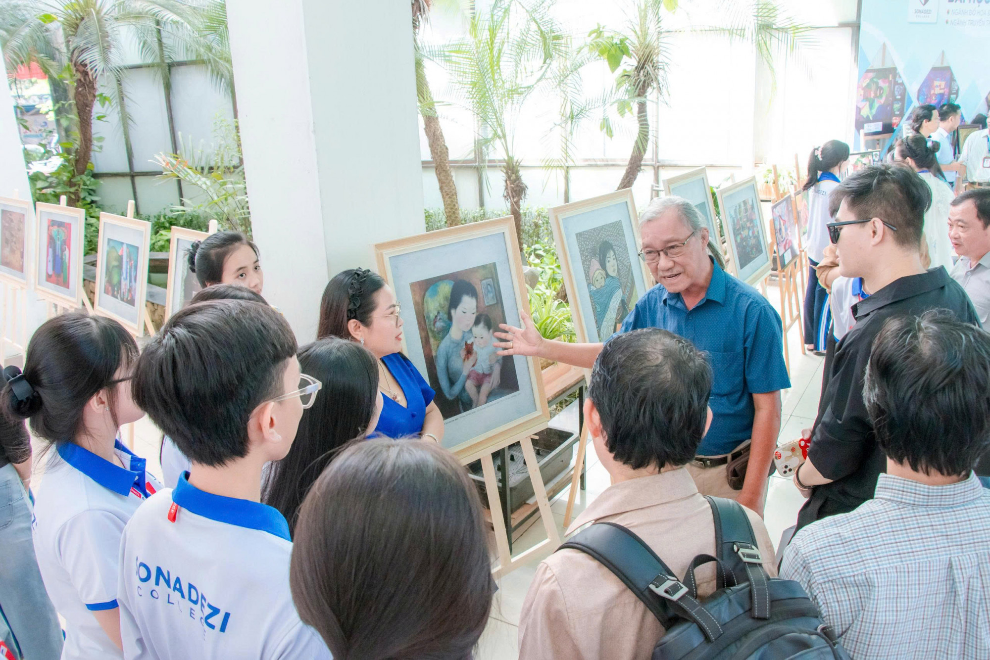 Sinh viên Trường Cao đẳng Công nghệ và Quản trị Sonadezi đang nghe giới thiệu về tranh hiện đại của các nữ họa sĩ Việt Nam tại triển lãm - Ảnh: Sonadezi