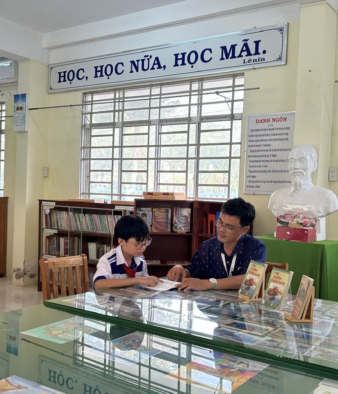 Gia đình nuôi dưỡng tâm hồn trẻ thơ Em Mai Nguyễn Quốc Bảo cùng người thầy đã truyền cảm hứng đọc sách cho em - thầy Lê Tấn Thời, hiệu phó trường THCS Nguyễn Đăng Sơn (An Giang). Nguồn ảnh: NVCC