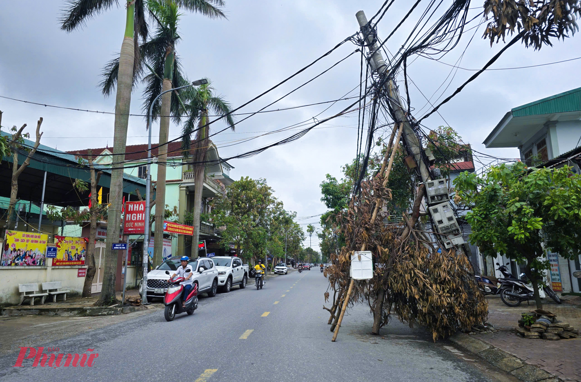 Một cột điện trên đường Trương Văn Lĩnh (thuộc thành phố Vinh, tỉnh Nghệ An trước đây) đổ nghiêng ra đường, đang phải “chống nạng” tạm thời bằng các cọc tre.
