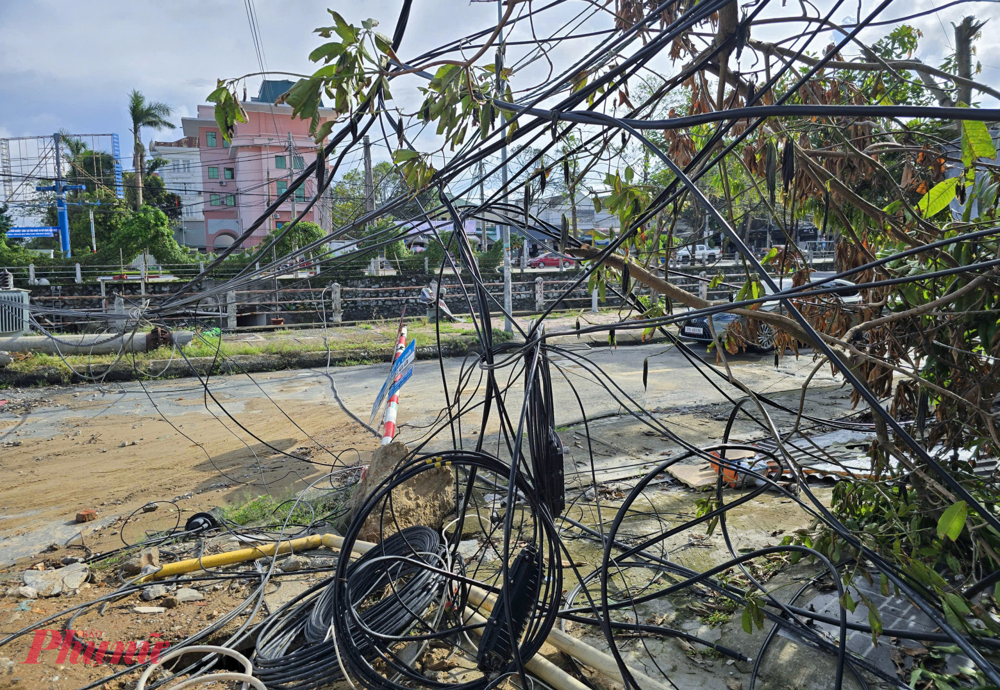 Hàng loạt dây điện, dây cáp viễn thông bị kéo đứt, chằng chịt, vắt ngang đường Phùng Chí Kiên. Người dân quanh khu vực cho biết, sau bão số 10, đoạn đường này gần như bị tê liệt vì dây điện, dây viễn thông đổ ngổn ngang, xe cộ phải đi đường vòng.