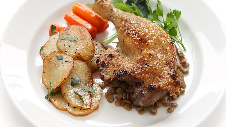 Confit de Canard là món vịt hầm mỡ trứ danh của vùng Gascony (Pháp), nổi bật với hương vị béo ngậy và độ mềm tan đặc trưng. Thịt vịt, thường là phần đùi, được ướp muối, tỏi và thảo mộc như hương thảo hoặc lá thyme rồi để nghỉ qua đêm cho thấm. Sau đó, vịt được nấu chậm trong chính mỡ của nó suốt nhiều giờ cho đến khi phần thịt mềm rục, da săn lại vàng óng và tỏa hương thơm quyến rũ. Nhờ cách nấu này, thịt vịt giữ nguyên vị ngọt tự nhiên, thớ thịt mềm mịn mà không hề khô.
