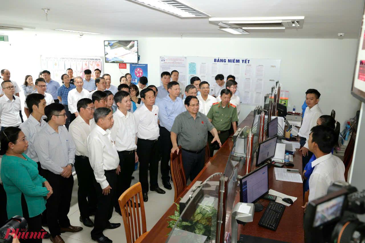 Thủ tướng Phạm Minh Chính trao đổi với cán bộ tại Trung tâm phục vụ hành chính công phường Hưng Phú. Ảnh: Trung Phạm