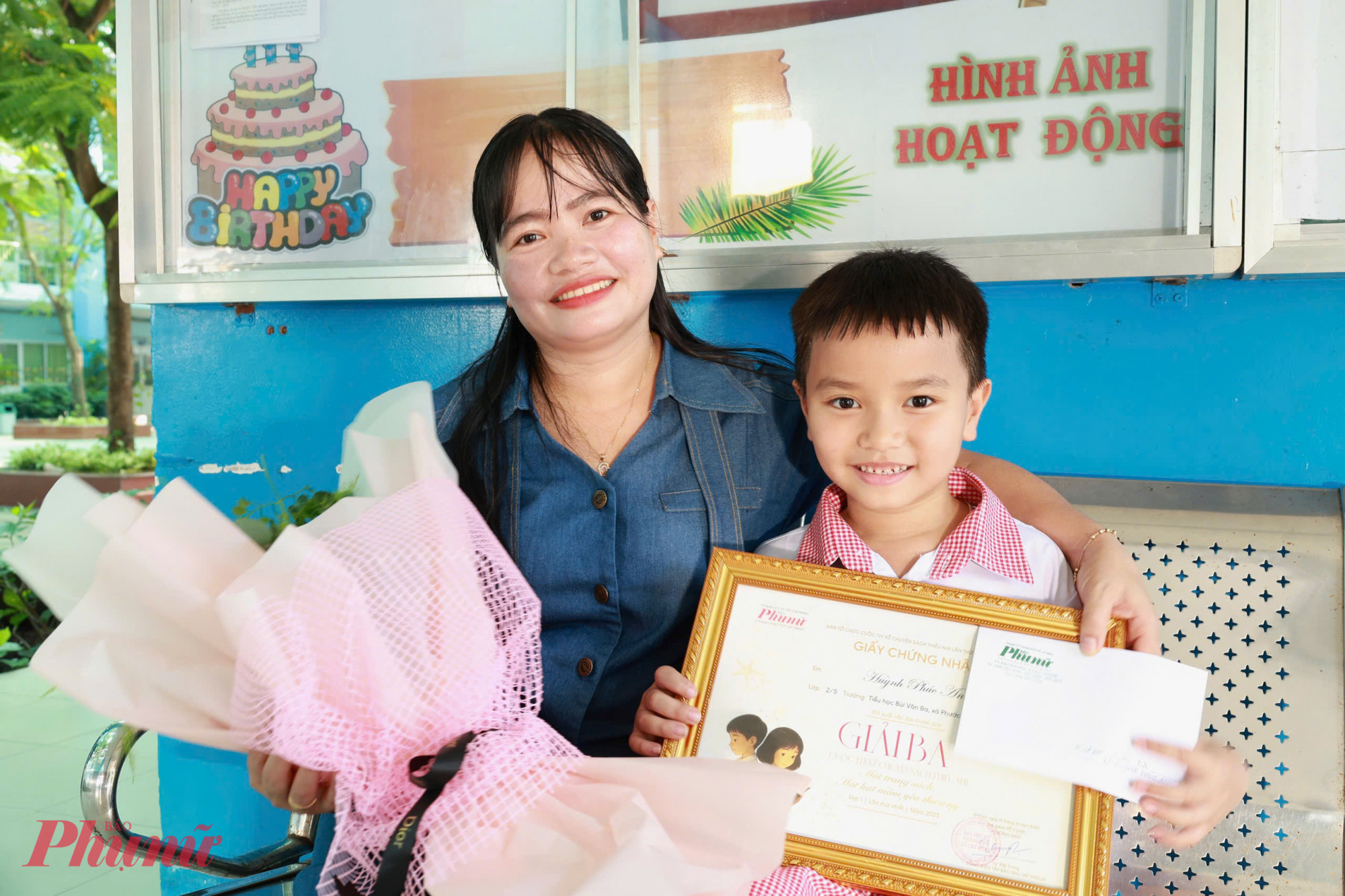 Chị Huỳnh Thị Nữ và em Huỳnh Phúc An chụp ảnh kỉ niệm cùng phần thưởng mới - Ảnh: Trang Thư